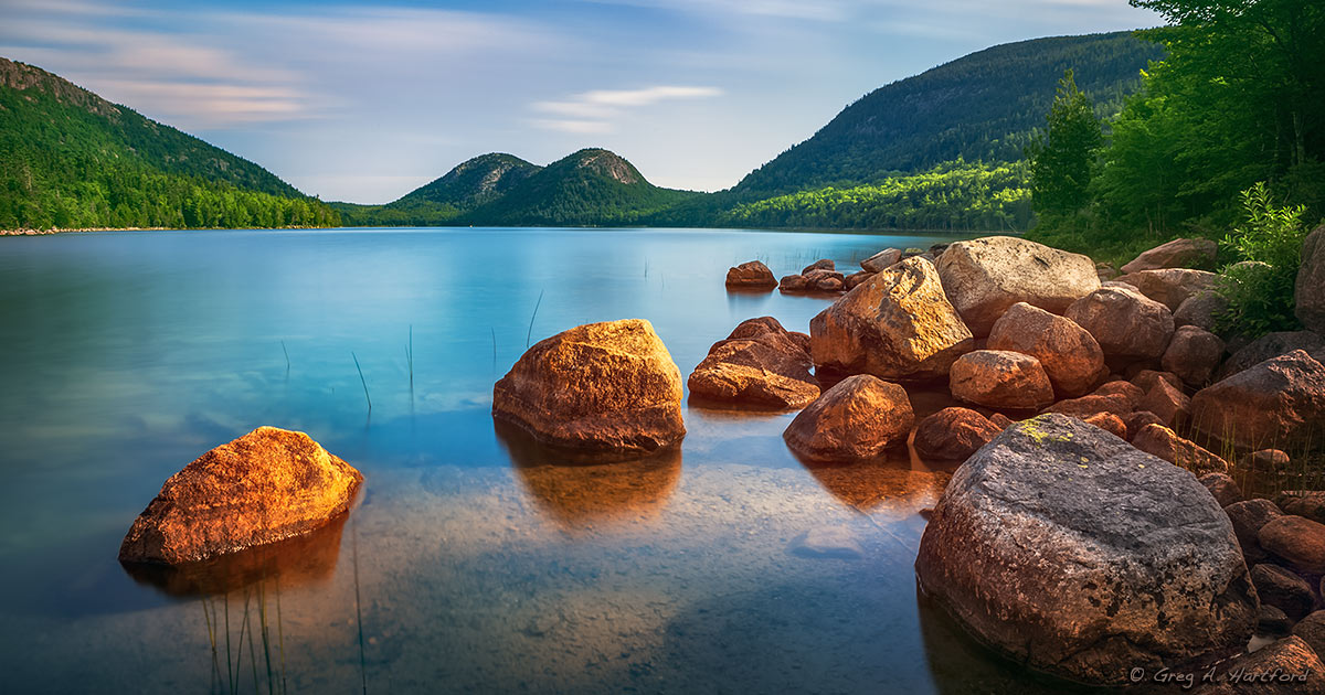 Jordan Pond with the Bubbles Mountains reflecting in calm water during fall foliage season in Acadia National Park